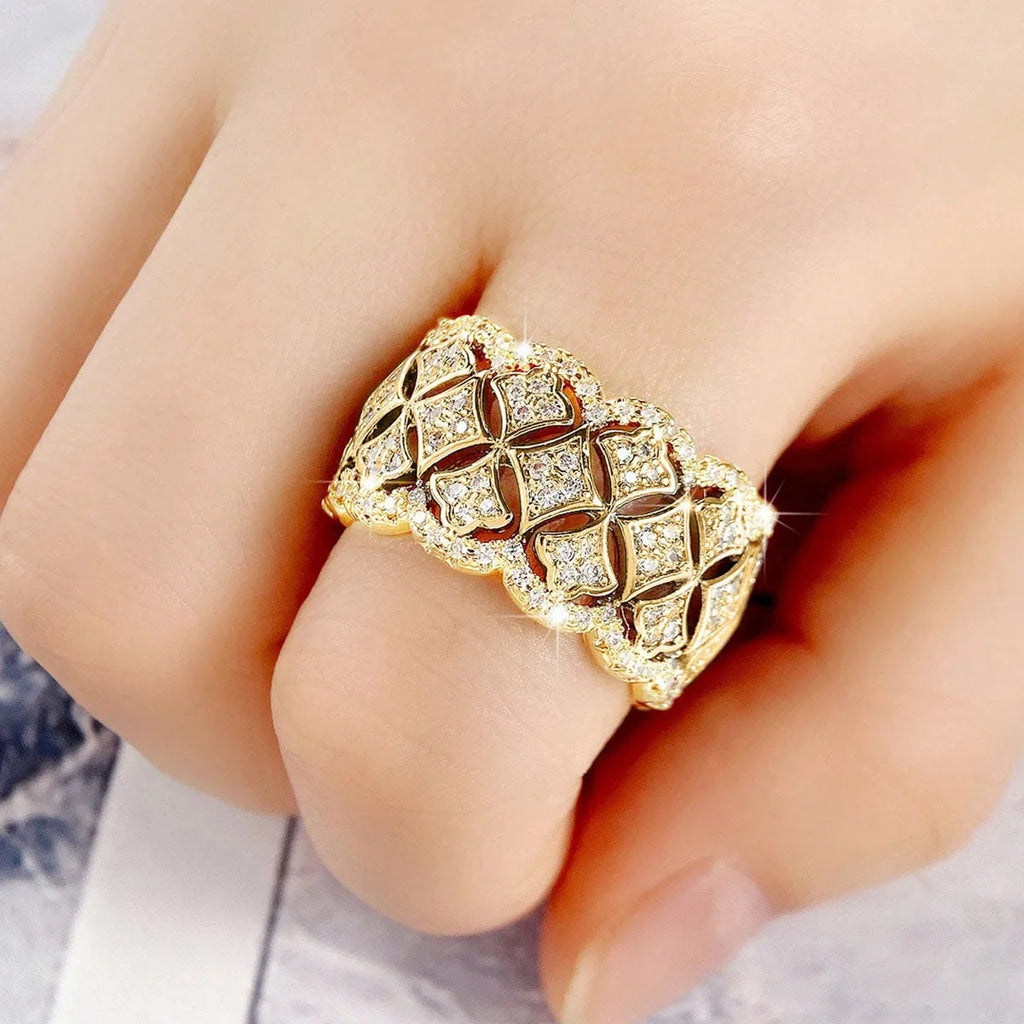 Bague dorée large pavée, motif dentelle vintage sur doigt, reflets des cristaux.