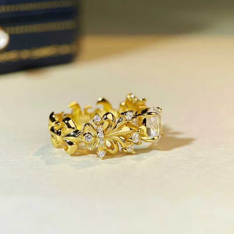 Bague Fleur de Lys dorée avec pierres transparentes et détails ajourés