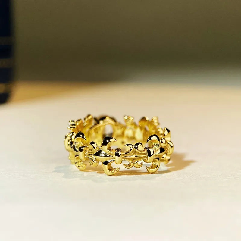 Bague dorée à motif Fleur de Lys, pierres transparentes serties