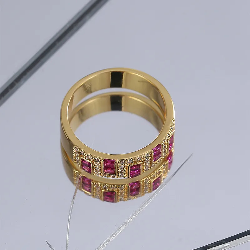 Bague plaquée or avec rangée de pierres rubis magenta et halo de zircons