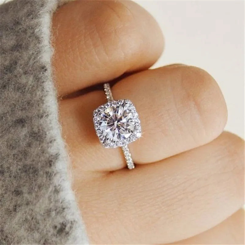 Bague solitaire argent 925 à zirconium blanc, monture carrée et halo étincelant.