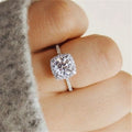 Bague solitaire argent 925 à zirconium blanc, monture carrée et halo étincelant.