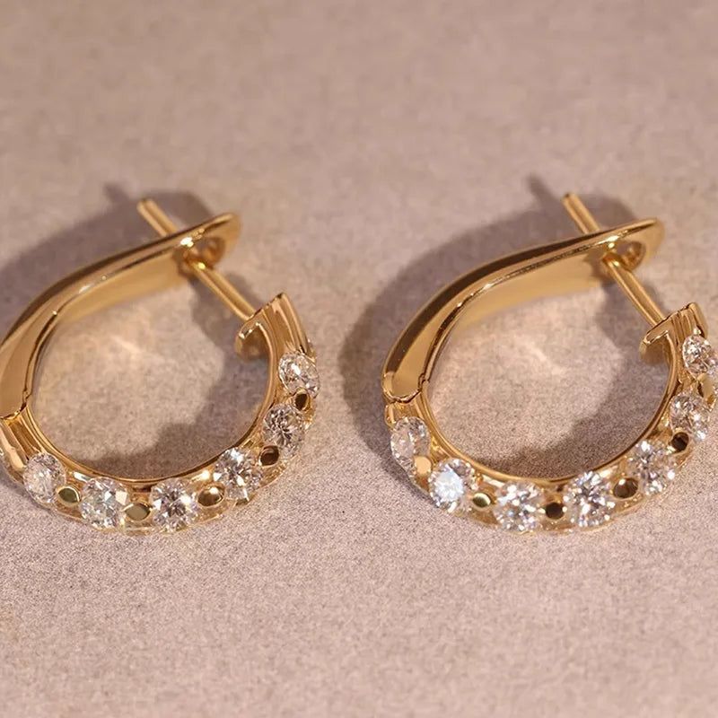 Petites créoles dorées, bord pavé de zircons ronds et fermoir visible