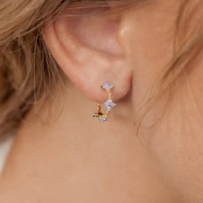 Créoles florales en argent 925 avec pierres opalescentes, portées sur l’oreille