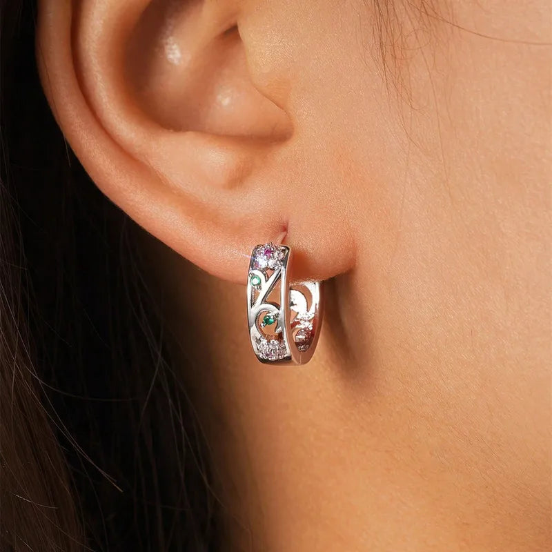 Créoles ajourées argenté, incrustations roses et vertes, portées à l’oreille
