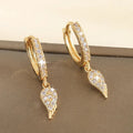 Paire de créoles dorées pavées de zirconiums avec pendent ailes d’ange.