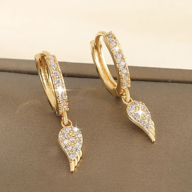 Paire de créoles dorées pavées de zirconiums avec pendent ailes d’ange.