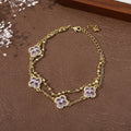 Bracelet double chaîne doré avec breloques trèfles en zirconium violet, chaînons fins.