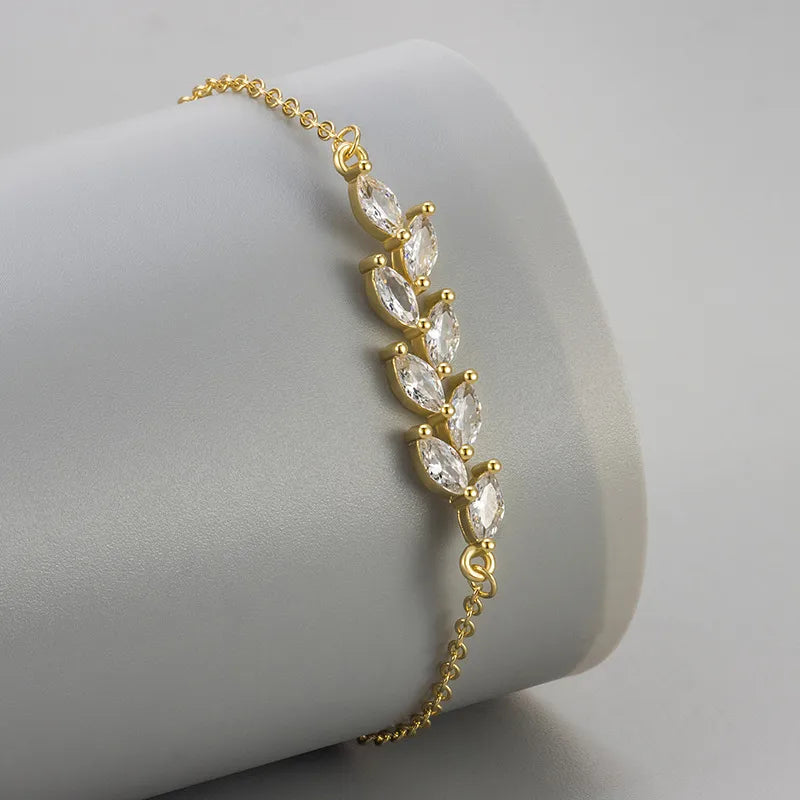 Bracelet doré motif feuillage, rangée de zircons marquise sur chaîne fine