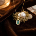 Collier pendentif ovale en nacre irisée sur chaîne dorée, fermoir discret