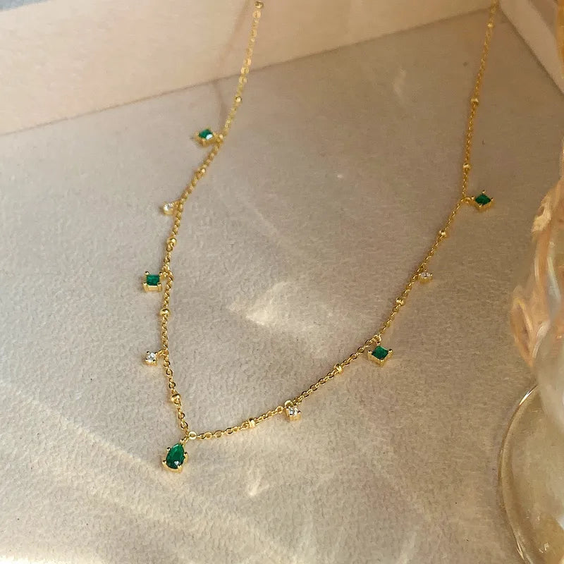 Collier à chaîne dorée avec pierres vertes émeraude et zircons blancs, pendentif.