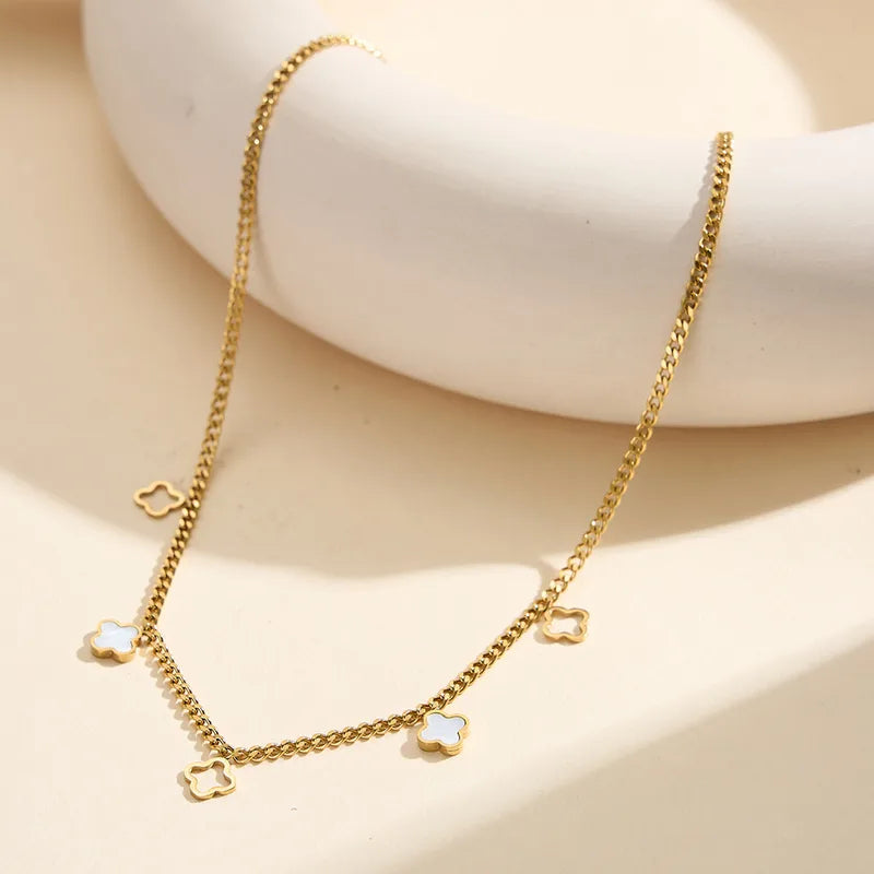 Collier doré à pendentifs trèfles nacrés, vue rapprochée sur la chaîne