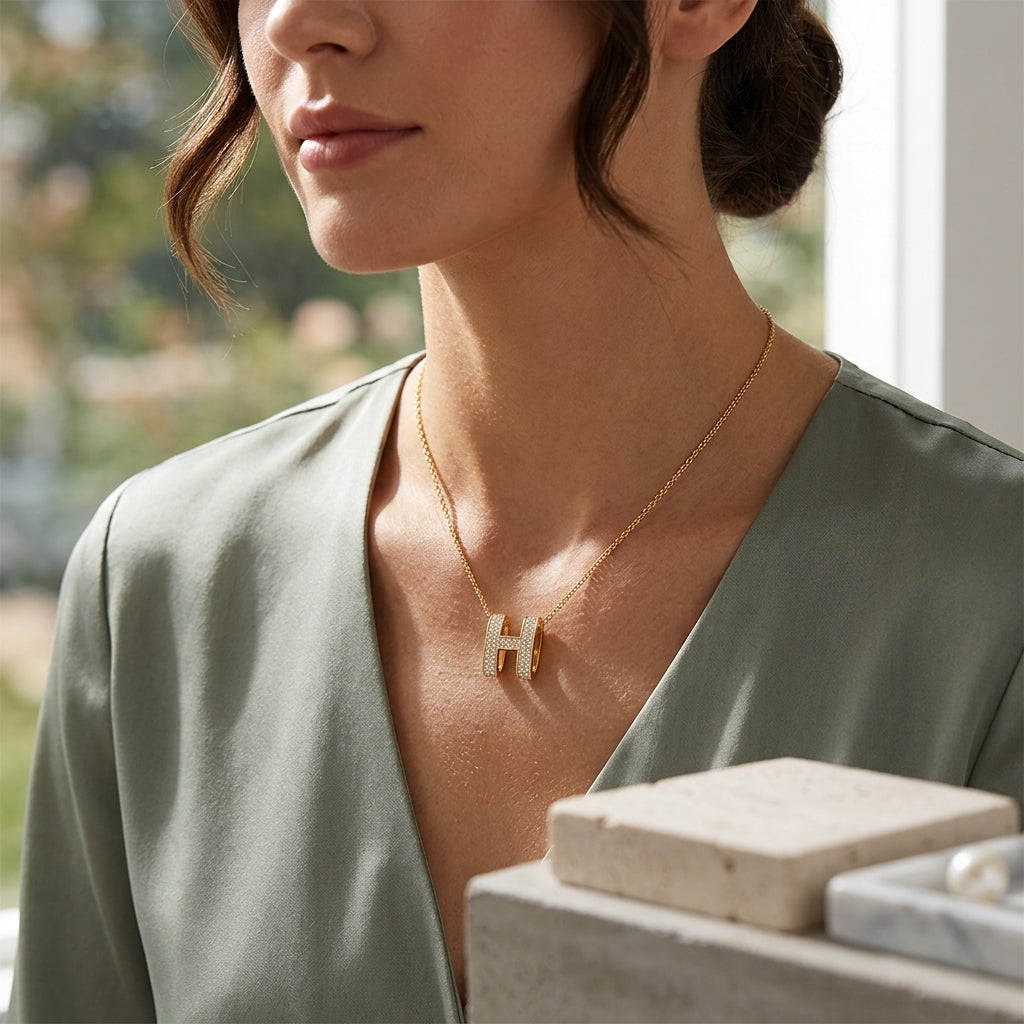 Collier initial «H» en plaqué or à pendentif scintillant de zircons, porté par la femme