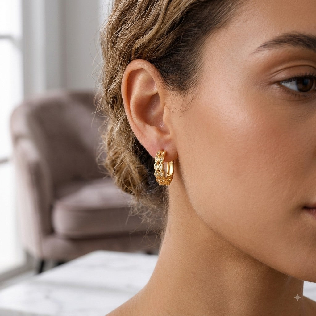 Créoles dorées à motif ondulé tressé et zircons, portées sur l’oreille