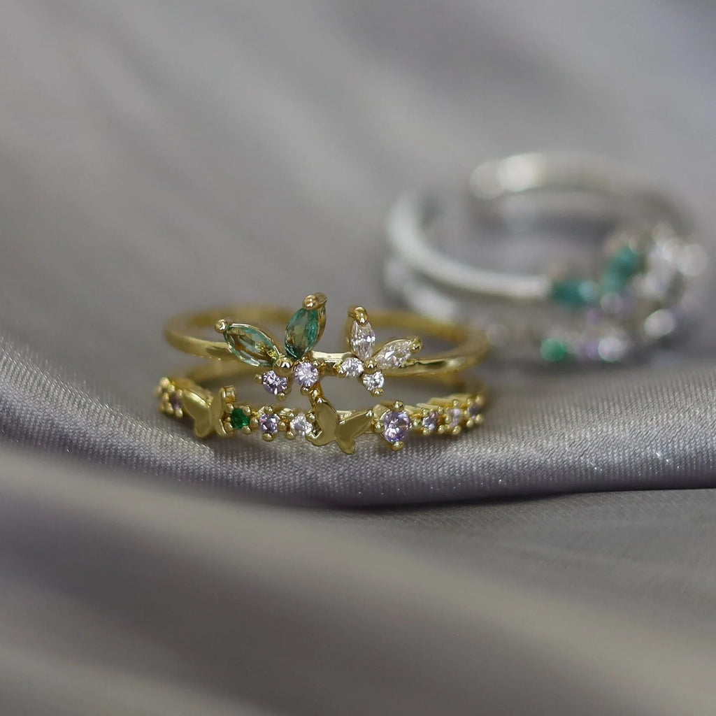 Bague ajustable double rang en acier doré, motifs papillons et fleurs, strass multicolores.