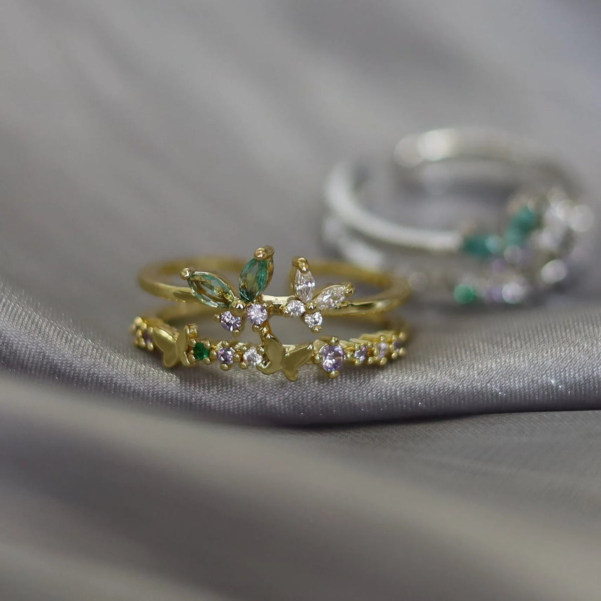 Bague ajustable double rang en acier doré, motifs papillons et fleurs, strass multicolores.
