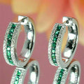 Boucles créoles argentées, rangée de pierres vert émeraude et pavage brillant