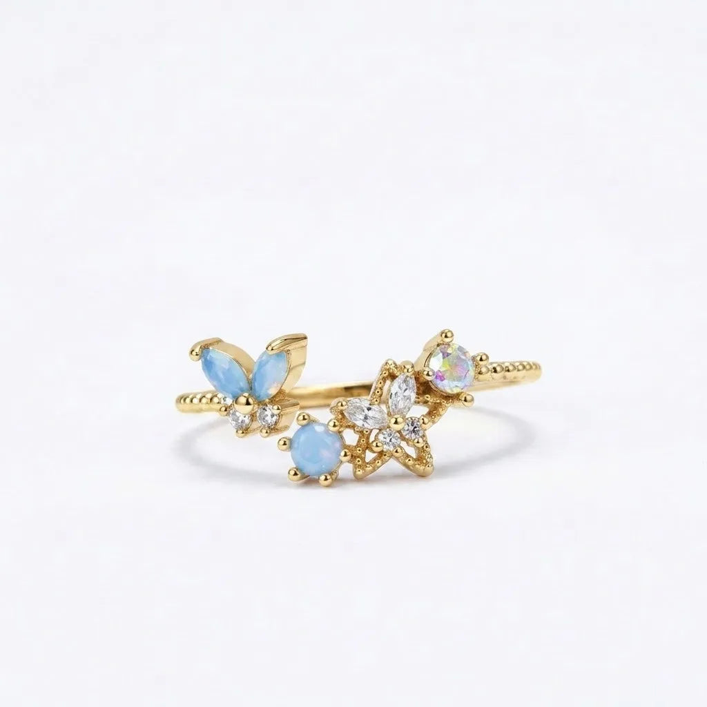 Bague papillon doré ajustable avec pierres bleues et fleurs opalines, acier inox.