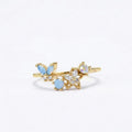 Bague papillon doré ajustable avec pierres bleues et fleurs opalines, acier inox.