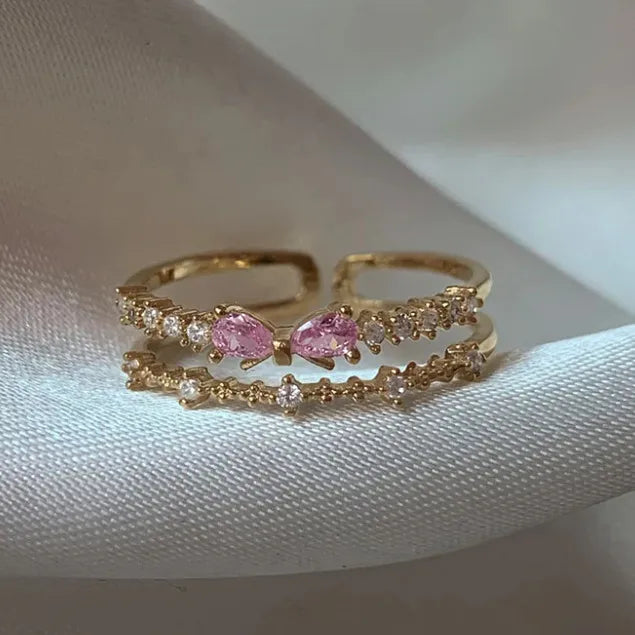 Bague ajustable double rang dorée à nœud, zircons rose pastel et pierres claires