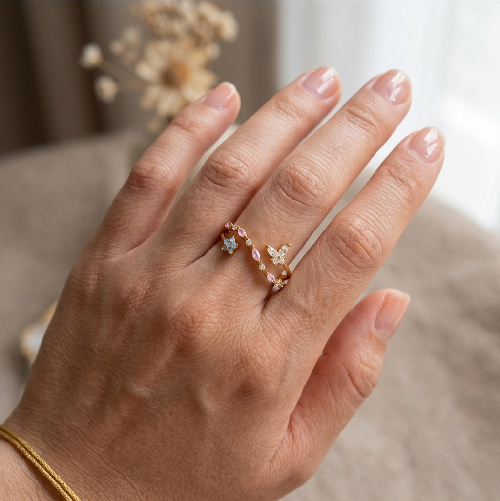 Bague ajustable plaquée or portée à la main, papillon zircons transparents, guirlande zircons roses et fleur opaline bleue — Jewelry by Kitana