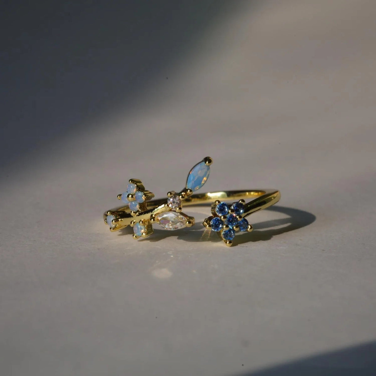 Bague plaquée or, fleurs bleues saphir et pierres opalescentes