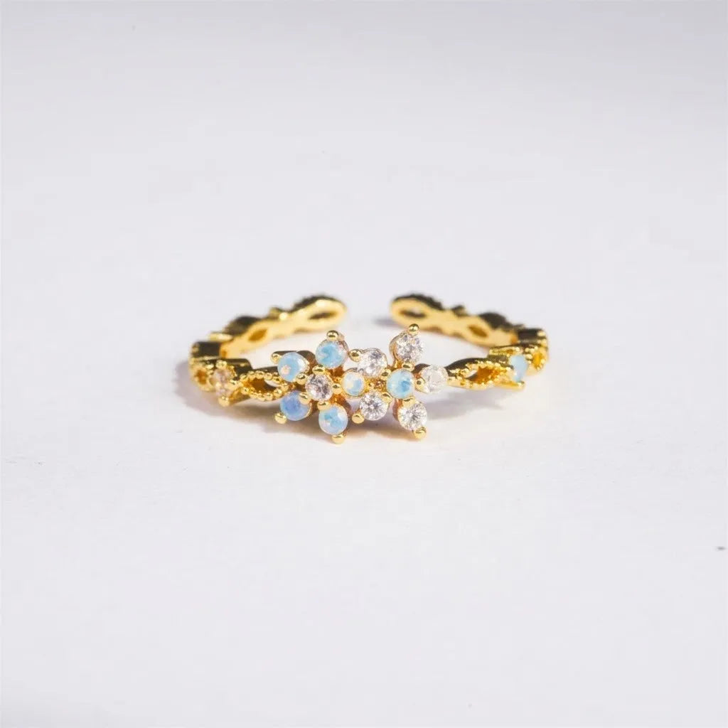 Bague dorée ajustable à motif fleurs, cristaux opalescents bleu clair