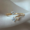 Bague réglable plaqué or avec fleurs bleu clair et feuilles serties de zircons