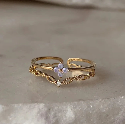 Bague dorée réglable à double rang dentelle filigranée avec pierre violette centrale.