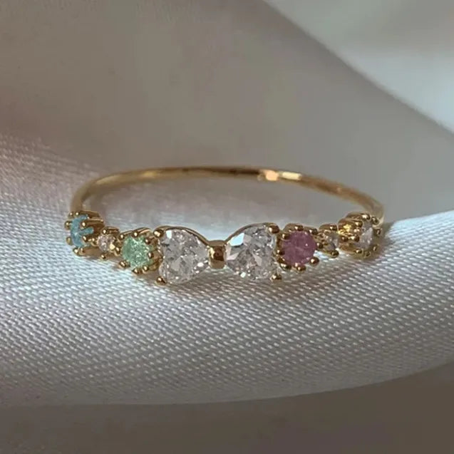 Bague nœud plaquée or avec zircons multicolores surmontant une pierre centrale