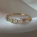 Bague nœud plaquée or avec zircons multicolores surmontant une pierre centrale