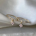 Bague ajustable dorée avec breloques fleurs roses et pierres claires, style tige fine.