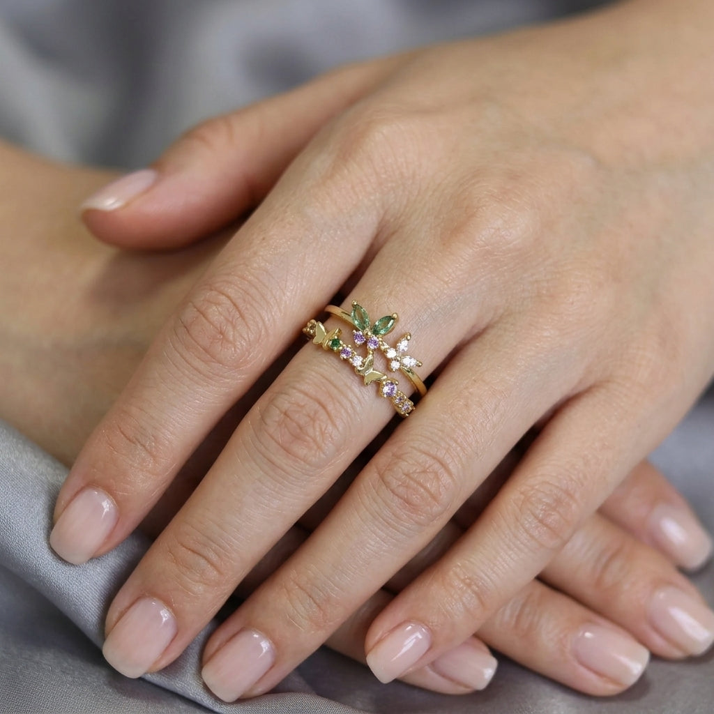 Bague double rang plaquée or portée à la main, motifs papillons et fleurs, zircons vert émeraude, lilas et blancs – Jewelry by Kitana`