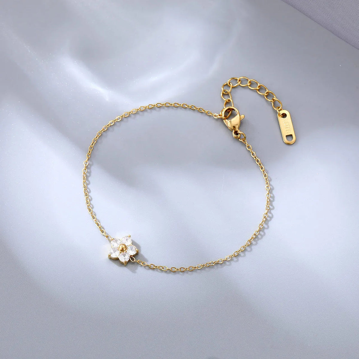 Bracelet plaqué or avec breloque fleur blanche en cristaux, fermoir mousqueton