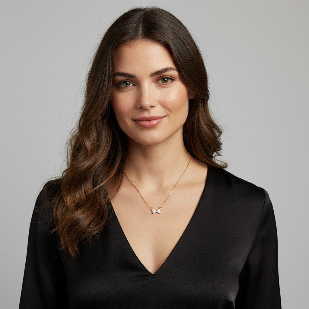 Collier fin au pendentif nœud papillon serti de zircons, porté près du cou
