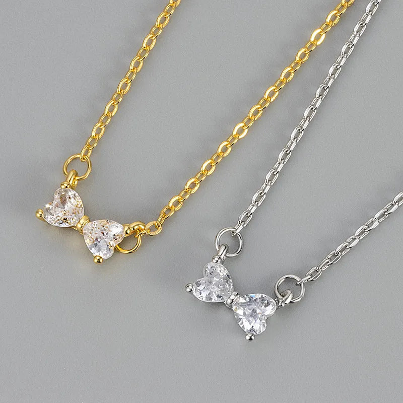 Collier à pendentif nœud papillon serti de zircons, chaînes dorée et argentée.