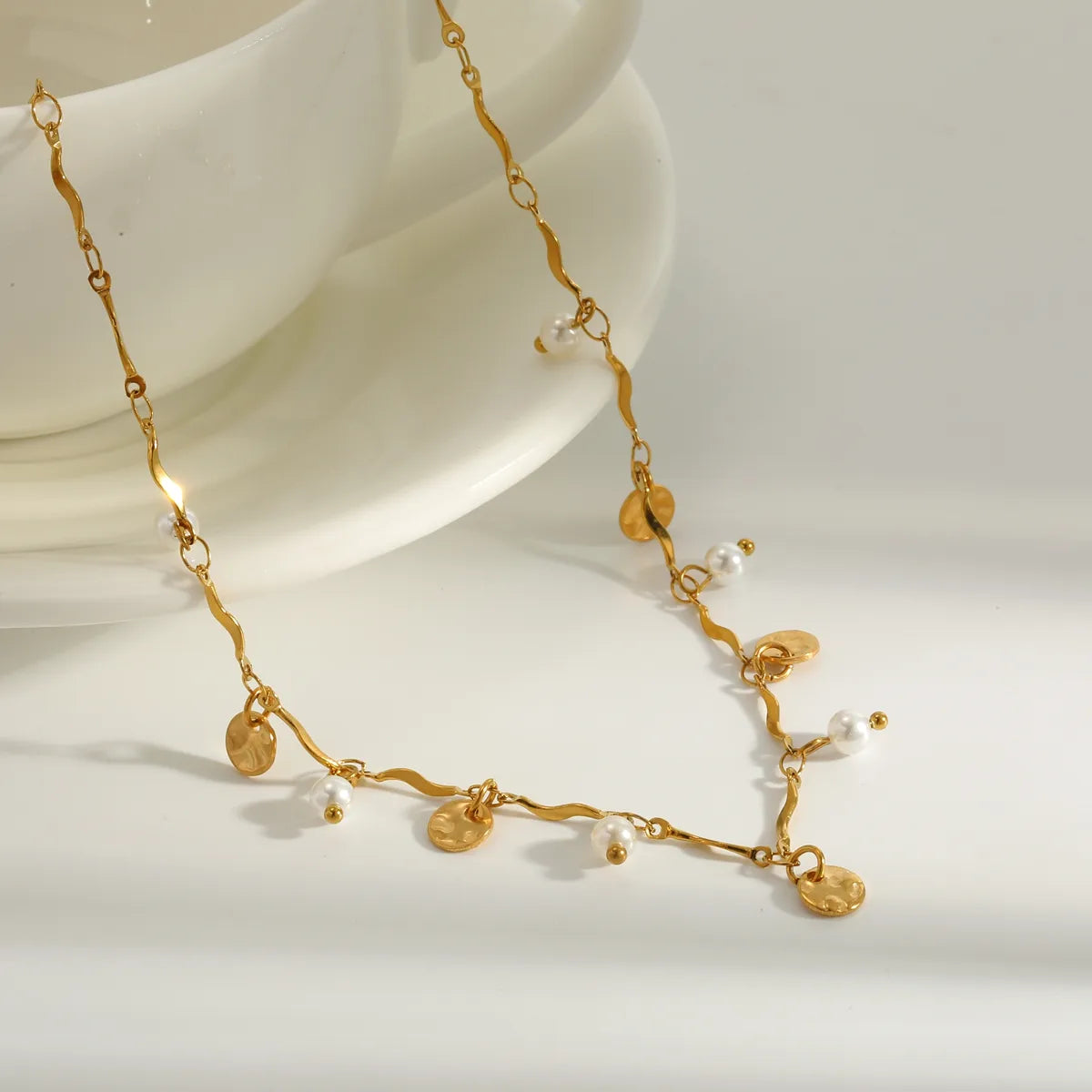 Collier chaîne dorée ondulée avec pastilles martelées, perles blanches et billes