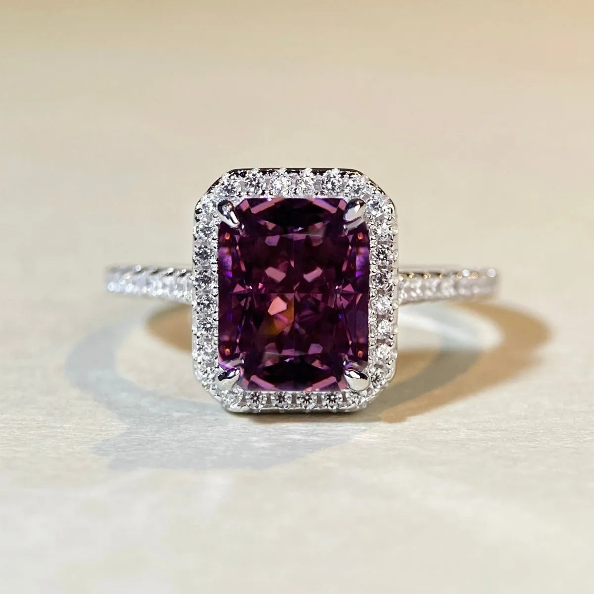 Bague solitaire en argent 925 à pierre coussin violette, halo pavé sur la monture.