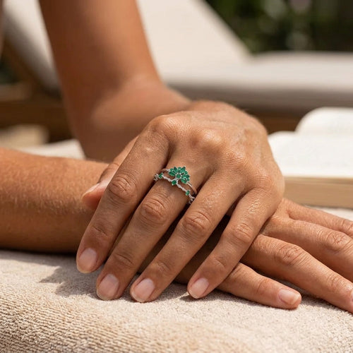 Bague ajustable argentée à zircons verts portée au doigt