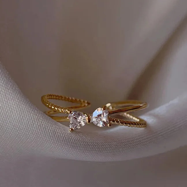 Bague ajustable à nœud en plaqué or 18k, sertie de deux zirconiums blancs.