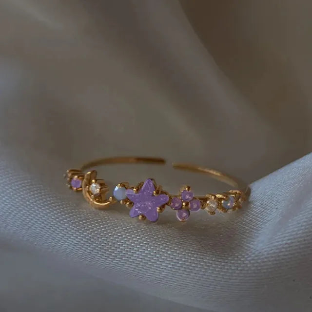 Bague ajustable en acier doré, motif d’étoiles en zircon violet.