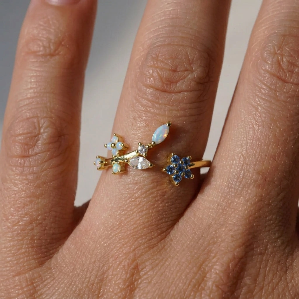 Bague ajustable dorée portée au doigt, fleur bleue saphir et feuillage opale irisé avec cristal marquise, style jardin céleste – Jewelry by Kitana