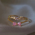 Bague Jewelry by Kitana ajustable double rang en acier doré avec fleurs lilas et cœurs roses en zirconiums