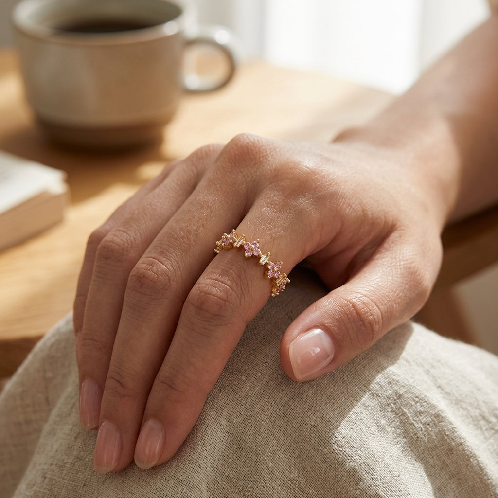 Bague fleurs zircons roses et baguettes blanches ajustable plaquée or 18K portée à la main, ambiance lifestyle chaleureuse — Jewelry by Kitana