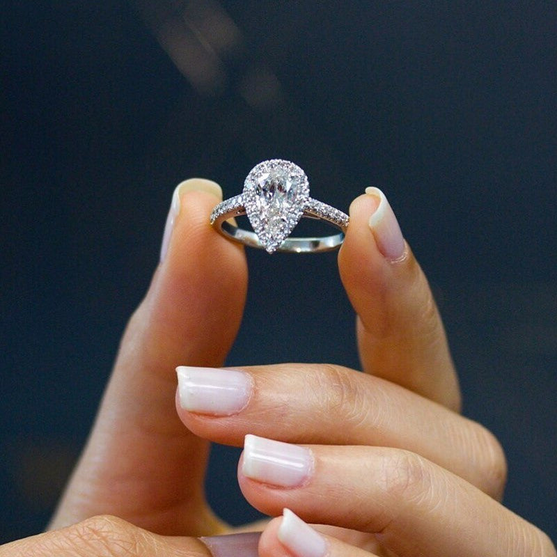 Bague argentée zircon blanc goutte présentée seule sur fond neutre
