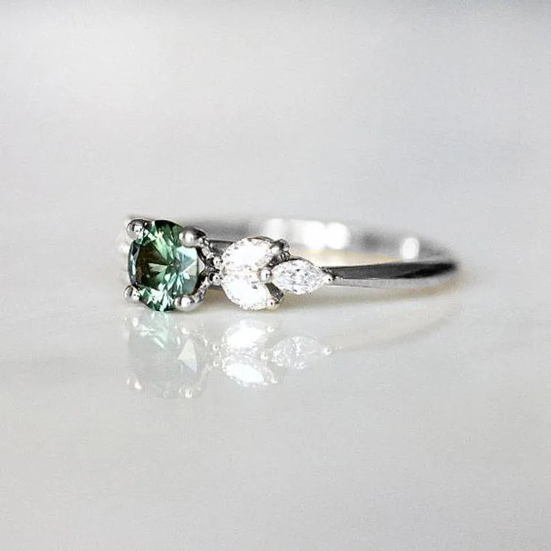Détail bague halo zircon vert kaki entourée de zircons blancs, acier inoxydable plaqué argent