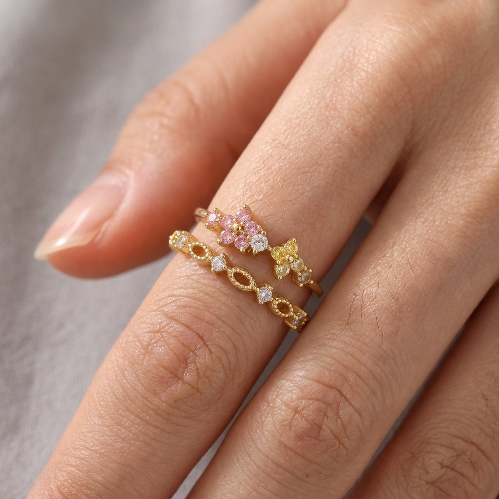 Bague double rang dorée portée au doigt, fleurs scintillantes roses et jaunes avec cristaux blancs sur anneau ajouré ciselé – Jewelry by Kitana