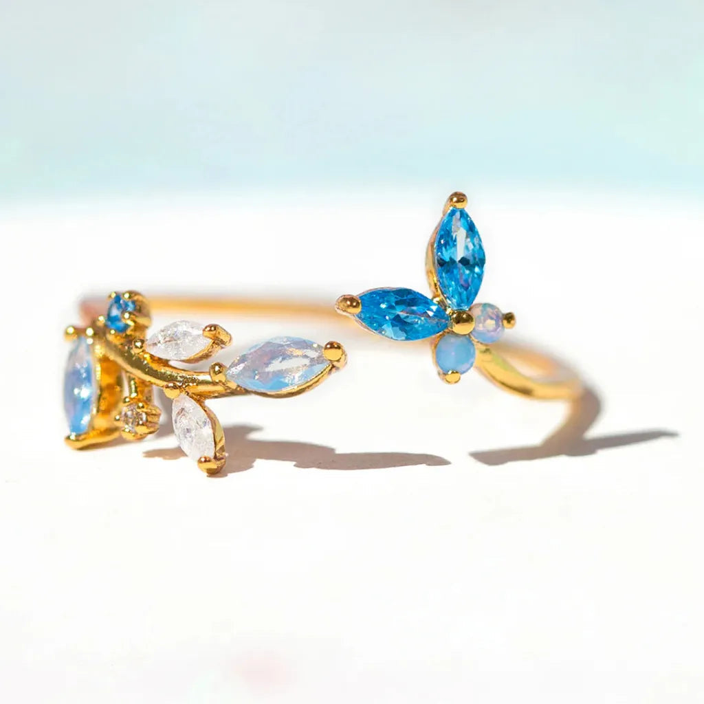 Bague dorée motif papillon, zircons et pierres bleues ovales et petites inclusions claires