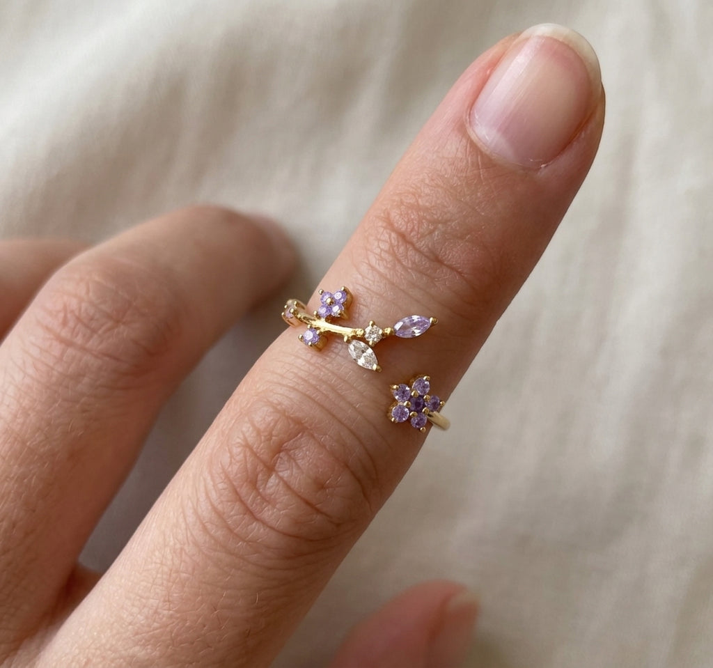 Bague ajustable dorée portée au doigt, motif branche avec fleurs et zircons violets et cristaux marquises – Jewelry by Kitana
