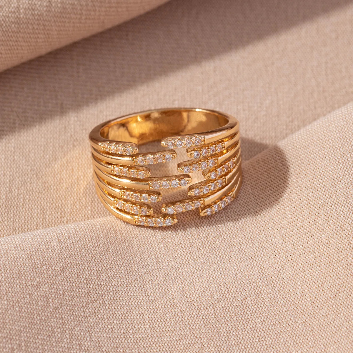 Bague dorée large multi-rang en strass, motif entrelacé, vue de dessus.
